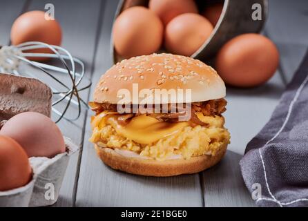 Köstliche Aussicht auf einen riesigen Burger unter seinen Zutaten auf Grauer Holztisch Stockfoto