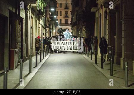 Barcelona, Spanien. Januar 2021. Demonstranten marschieren auf der Straße mit einem Banner, auf dem steht, das Fernsehen ausschalten, auch während der Parade hocken. Zeitgleich mit der Nacht der Könige, gefeiert in ganz Spanien mit typischen Paraden, hat die Hausbesetzer Bewegung von Barcelona eine Parade durch die Straßen von Barcelona organisiert Credit: SOPA Images Limited/Alamy Live News Stockfoto