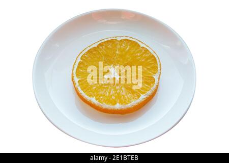 Platte mit einer Scheibe getrocknetes Orange isoliert auf weißem Hintergrund. Stockfoto
