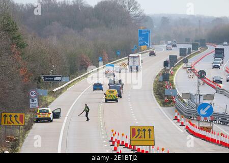 Ashford, Kent, Großbritannien. Januar 2021, 06. Auf der M20 stehen noch Lastwagen zwischen den Kreuzungen 8 und 9 in der Schlange, da die Operation Brock jetzt in Betrieb ist. Bewegliche Betonblöcke befinden sich auf der London Bound Lane, damit der Verkehr in beide Richtungen fließen kann. Das Polizeiamt hält an und nimmt Trümmer auf der Autobahnspur auf. Foto-Kredit: PAL Media-Paul Lawrenson/Alamy Live Nachrichten Stockfoto