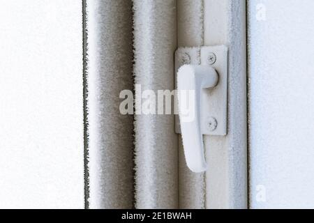 Das Thema des Einfrierens von Haus Kunststoff-Fenster im Haus aufgrund des Alters. Das Konzept der Fensterisolierung vor dem Winter. Stockfoto