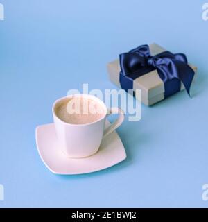 Tasse Kaffee und Geschenk in einer Box auf klassisch blauem Hintergrund. Valentinstag, Geburtstag oder Womens Day Konzept. Stockfoto