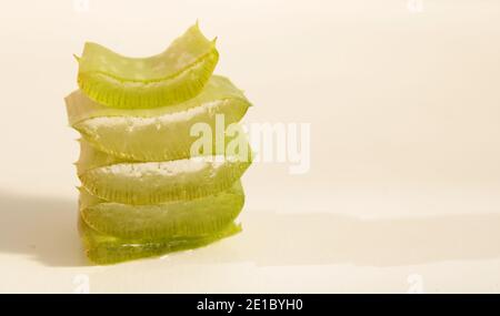 Schneiden Sie Stücke von Aloe Vera Blatt auf weißem Hintergrund. Hausgemachtes medizinisches Aloe-Gel. Stockfoto