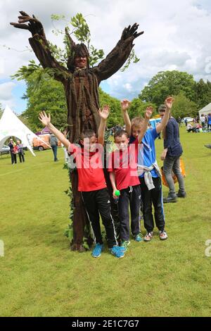 Alloway, Ayrshire, Schottland, Großbritannien, das jährliche Burns an A That Festival . Eine kostenlose Veranstaltung, die vom South Ayrshire Council organisiert wird, um den einheimischen schottischen Dichter Robert Burns zu feiern. Das Festival bietet verschiedene Veranstaltungen von Live-Musik, Wohltätigkeitsstand, Kostümkleid, kostümierte Charaktere, Entertainer, Buskersfun für Erwachsene und Kinder gleichermaßen. Ein Mann, wie ein Baum gekleidet, nähert sich einer Gruppe von Frauen Stockfoto