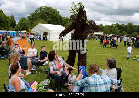 Alloway, Ayrshire, Schottland, Großbritannien, das jährliche Burns an A That Festival . Eine kostenlose Veranstaltung, die vom South Ayrshire Council organisiert wird, um den einheimischen schottischen Dichter Robert Burns zu feiern. Das Festival bietet verschiedene Veranstaltungen von Live-Musik, Wohltätigkeitsstand, Kostümkleid, kostümierte Charaktere, Entertainer, Buskersfun für Erwachsene und Kinder gleichermaßen. Ein Mann, wie ein Baum gekleidet, nähert sich einer Gruppe von Frauen Stockfoto