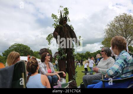 Alloway, Ayrshire, Schottland, Großbritannien, das jährliche Burns an A That Festival . Eine kostenlose Veranstaltung, die vom South Ayrshire Council organisiert wird, um den einheimischen schottischen Dichter Robert Burns zu feiern. Das Festival bietet verschiedene Veranstaltungen von Live-Musik, Wohltätigkeitsstand, Kostümkleid, kostümierte Charaktere, Entertainer, Buskersfun für Erwachsene und Kinder gleichermaßen. Ein Mann, wie ein Baum gekleidet, nähert sich einer Gruppe von Frauen Stockfoto