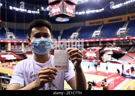 Peking, Chinas Provinz Shandong. Juli 2020. Su Kefan, der erste Zuschauer der wiederaufgenommenen Liga der Chinesischen Basketballvereinigung (CBA) 2019/20, zeigt sein Ticket auf dem Stand vor einem Spiel zwischen Shanghai Sharks und Shandong Heroes in Qingdao, der ostchinesischen Provinz Shandong, 26. Juli 2020. Die Chinese Basketball Association (CBA) Liga wieder am 20. Juni nach einer fast fünfmonatigen Pause. Kredit: Guo Xulei/Xinhua/Alamy Live Nachrichten Stockfoto