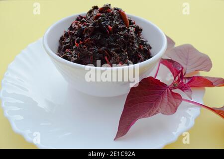 Rote Chowli bhaji oder Amaranth Blätter. Indisches Curry-Sabji aus frischen roten Spinat-Amaranth-Blättern. Leckeres Gericht in weißer Schüssel serviert Stockfoto