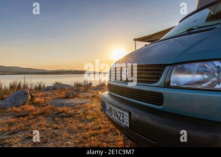 Sonnenaufgang beim Camping mit Offroad Camper VW T4 Syncro California Reisebus-Campervan mit Pop-up-Dach am Lake Alto Rabagão Dam - nördlich von Portugal Stockfoto