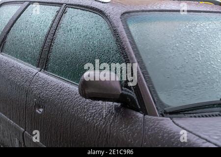 Eisiger Rückspiegel, Windschutzscheibe, Auto mit Eiszapfen, Eis aus nächster Nähe. Gefrorenes Auto Stockfoto