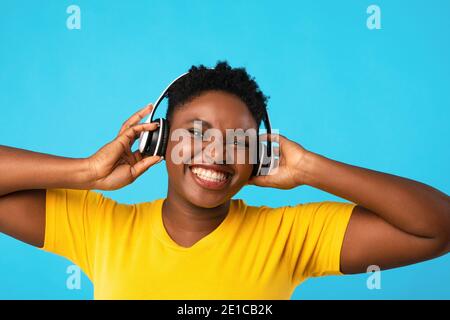 Schwarze Frau Trägt Kopfhörer Musik Auf Blauem Hintergrund Hören Stockfoto