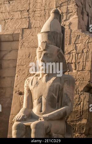 Luxor. Dies ist eine von mehreren Statuen des Pharao König Ramesses II am Eingang zum 3500 Jahre alten UNESCO-Weltkulturerbe des Tempels von Luxor, Teil des größten Tempelkomplexes der Welt, Das Hotel liegt auf dem Nil an der Stadt Luxor früher in der alten Welt als Theben bekannt, deren Bau ist weitgehend gutgeschrieben Ramesses II, Ramesses der große. Stockfoto