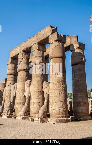 Luxor. Massive Steinsäulen und kopflose Statuen von Ramesses II im Innenhof des 3500 Jahre alten UNESCO-Weltkulturerbes des Luxor-Tempels, Teil des größten Tempelkomplexes der Welt, Das Hotel liegt auf dem Nil an der Stadt Luxor früher in der alten Welt als Theben bekannt, deren Bau ist weitgehend gutgeschrieben Ramesses II, Ramesses der große. Stockfoto