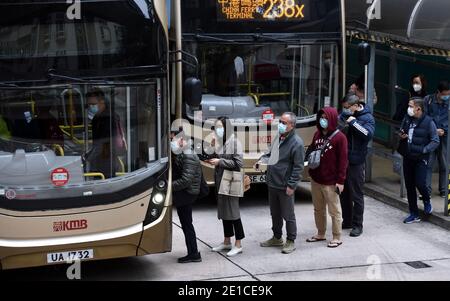 (210106) -- HONGKONG, 6. Januar 2021 (Xinhua) -- Menschen mit Gesichtsmasken steigen in einen Bus in Hongkong, Südchina, 6. Januar 2021. Hongkongs Zentrum für Gesundheitsschutz meldete am Mittwoch 25 weitere bestätigte Fälle von COVID-19, ein neuer Tiefstand seit Ende November, der sich auf 9,074 annahm. (Xinhua/Lo Ping Fai) Stockfoto