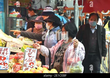 Hongkong, China. Januar 2021. Menschen mit Gesichtsmasken kaufen Früchte in Hongkong, Südchina, 6. Januar 2021. Hongkongs Zentrum für Gesundheitsschutz meldete am Mittwoch 25 weitere bestätigte Fälle von COVID-19, ein neuer Tiefstand seit Ende November, der sich auf 9,074 annahm. Kredit: Lo Ping Fai/Xinhua/Alamy Live Nachrichten Stockfoto