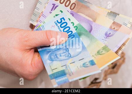 Indonesisches Geld in der Hand, verschiedene Banknoten Stockfoto