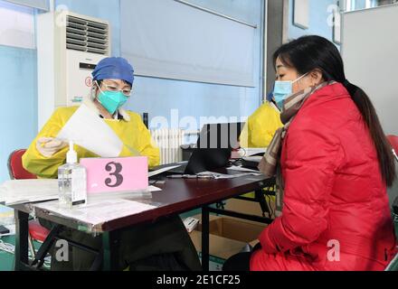 (210106) -- PEKING, 6. Januar 2021 (Xinhua) -- EINE Frau registriert sich für die COVID-19-Impfung an einer temporären Impfstelle im Bezirk Haidian in Peking, Hauptstadt von China, 6. Januar 2021. (Xinhua/Ren Chao) Stockfoto