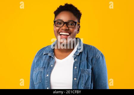Fröhliche Afrikanische Plus-Size Frau Posiert Über Yellow Studio Hintergrund Stockfoto