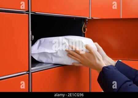 Senden oder empfangen Paket mit Self-Service-Post-Terminal-Maschine. Hand mit Paket Stockfoto