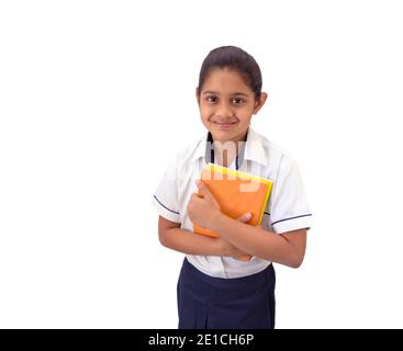 Porträt eines glücklichen indischen Schulmädchen in Uniform lächelnd und hält Notizen Bücher. Stockfoto