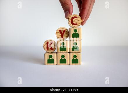 KYC - Know your Customer Symbol. Konzept Worte "KYC - Know your Customer" auf Holzwürfel und Kreise auf einem schönen weißen Hintergrund. Männliche Hand. Busi Stockfoto