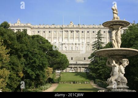 Besucher und Touristen zu Fuß in Jardines de Sabatini Gärten mit der Nordfassade des Königspalastes in Madrid. Stockfoto