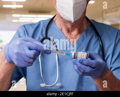 Senior Mann Krankenschwester mit Spritze Vorbereitung einer Dosis der Impfstoff in einer Klinik oder Arztpraxis zur Immunisierung Stockfoto