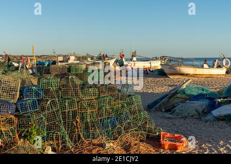 Amarcao da Pera, Portugal - 30. Dezember 2020: Sonnenuntergang am Praia do Pescadores an der Algarve Küste Portugals mit Fischerbooten und Ausrüstung Stockfoto