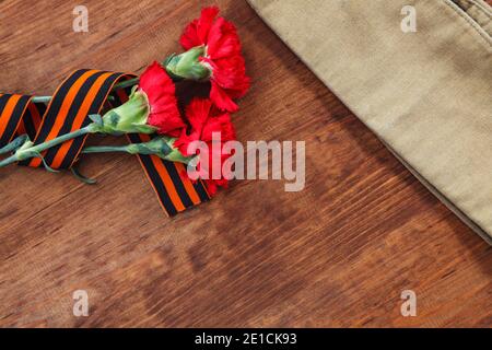 Drei rote Blume und Papier und der Soldat Futter Gap auf einer hölzernen Hintergrund. selektive Fokus Bild Stockfoto