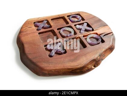 Lila Stein Tic tac Zehenstücke auf Holz Spielbrett Entworfen von Anna Rabinowicz auf weißem Hintergrund fotografiert Stockfoto