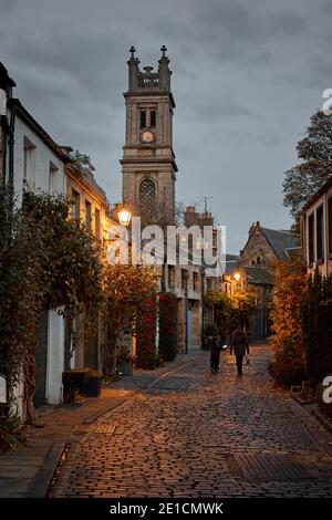 Die berühmte Circus Lane, in Stockbridge Gegend von Edinburgh, Schottland. Nachtzeit, Winter 2020. Kirchturm, und Zifferblatt in der Ferne Stockfoto