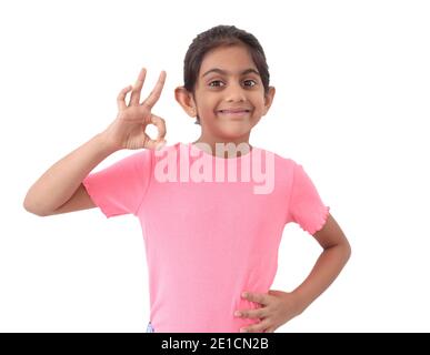 Portrait eines niedlichen kleinen indischen Mädchen zeigt "perfekte" Form Zeichen mit Händen und zum Ausdruck bringen Zufriedenheit und Wertschätzung. Stockfoto