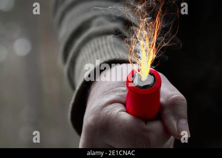 Industrielle Batterie in einem Mann Faust, aus der schießen Blitz und Rauch Wolken schweben, Composite-Bild, Konzept Stockfoto