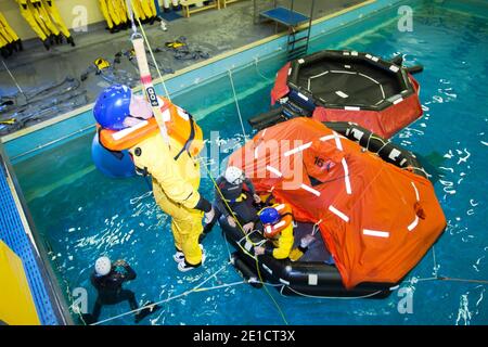 Arbeiter in der Offshore-Industrie üben die Evakuierung von Helikoptern im Rahmen eines Industrieschulungskurses aus, den alle Offshore-Mitarbeiter benötigen Stockfoto