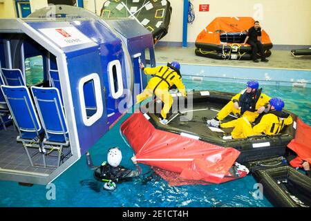 Arbeiter in der Offshore-Industrie üben die Evakuierung von Helikoptern im Rahmen eines Industrieschulungskurses aus, den alle Offshore-Mitarbeiter benötigen Stockfoto