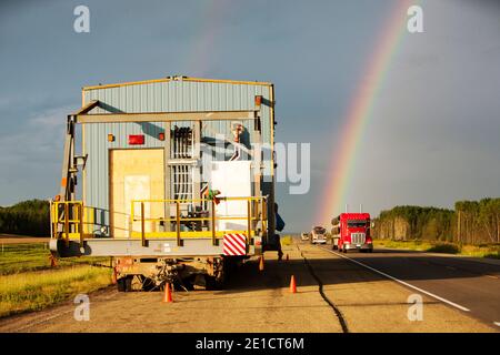 Auf der Straße nach Fort McMurray, dem Zentrum der Ölsandindustrie, transportieren Lastwagen eine übergroße Ladung an Teersand-Ausrüstung. Die Alberta Teersand in Stockfoto