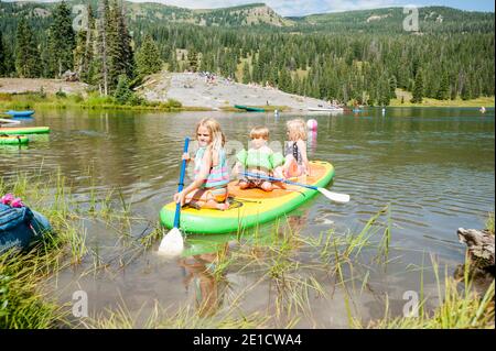 Kinder auf dem Paddleboard, Lake Irwin, Irwin, Colorado, USA Stockfoto