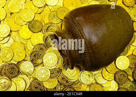 Goldmünze im Schatz alter Tontopf auf einem Stapel Von Goldmünzen Stockfoto