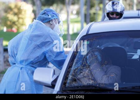 Medizinisches Personal der National Health Organization (EODY) führt einen COVID-19 Schnelltest an Autofahrern an einem Drive-Through-Testgelände im Zentrum von Athen durch. Stockfoto