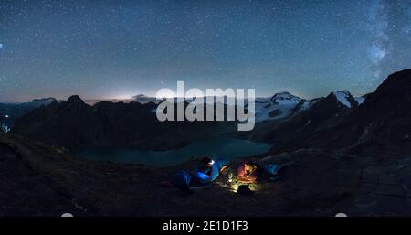 Blick auf ein Paar, das unter Nachthimmel auf Schlafsäcken liegt, Verbano-Cusio-Ossola, Italien Stockfoto