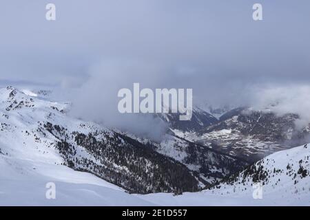 Blick auf das verschneite Villgratental zwischen Österreich Alpen in Tirol in Westösterreich. Die Gipfel dieser 2.000-Meter-Berge sind im Nebel und verloren Stockfoto