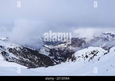 Blick auf das verschneite Villgratental zwischen Österreich Alpen in Tirol in Westösterreich. Die Gipfel dieser 2.000-Meter-Berge sind im Nebel und verloren Stockfoto