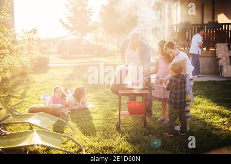 Große glückliche Familie genießen Grillen in ihrem Hinterhof an einem sonnigen Tag. Stockfoto