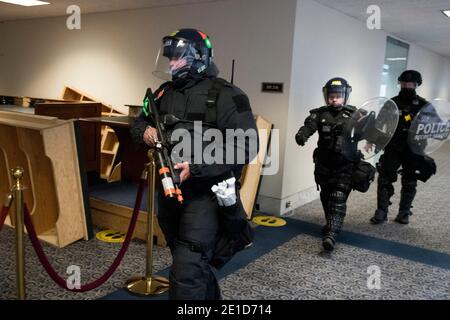 Washington DC, USA. Januar 2021. Mitglieder eines taktischen Teams des Geheimdienstes kommen an, als Senatoren an einen sicheren Ort im Dirksen Senatsbüro evakuieren, nachdem während einer gemeinsamen Sitzung des US-Kongresses Wahlstimmen gezählt wurden, um die Ergebnisse der Präsidentschaftswahlen 2020 im US-Repräsentantenhaus zu bestätigen Kammer im US-Kapitol in Washington, DC am Mittwoch, den 6. Januar 2021, so unterbrochen, wie Tausende von PR-Trump-Demonstranten das US-Kapitol und die Kammer des Repräsentantenhauses stürmten. .Credit: Rod Lamkey / CNP /MediaPunch Credit: MediaPunch Inc/Alamy Live News Stockfoto