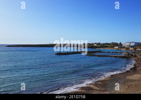 Wunderschöne Landschaft von Paphos Stadt mit mittelmeer und total blauen Himmel. Meeresküste mit Steinwracken und weißem Gebäude im Hintergrund. Stockfoto