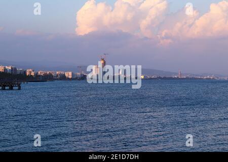 Wunderschöne Küste von Limassol bei Sonnenuntergang. Perfekte Küste von Lemesos mit vielen Hochhäusern. Wolkiger Himmel mit roten und rosa Farbe von Einstellung su Stockfoto