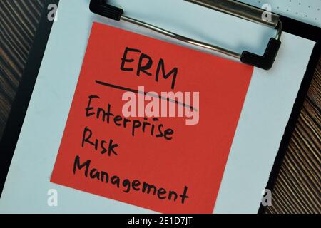 ERM - Enterprise Risk Management Schreiben Sie auf Haftnotizen isoliert auf Holztisch. Stockfoto