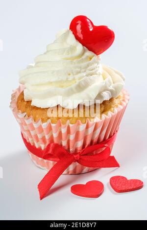 valentines Cupcake mit herzförmigen Karamell Süßigkeiten auf der Oberseite Stockfoto