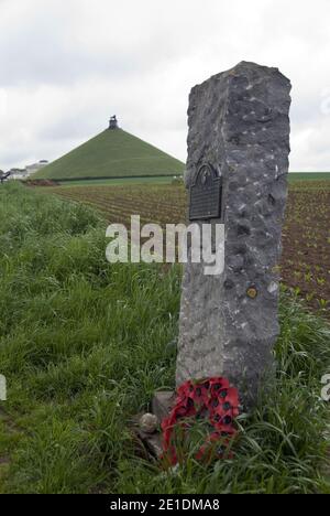 Ein Stein markiert die Position der Truppen auf dem Schlachtfeld von Waterloo, mit dem Löwenhügel am Horizont, Waterloo, Belgien. Stockfoto