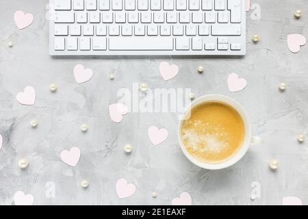 Computertastatur, Kaffee, rosa Herzen und Perlen Stockfoto